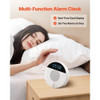 Lifestyle image of adult woman asleep with white noise machine next to her bed, lights dimmed for nighttime use