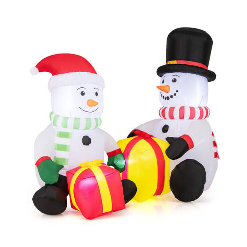 5-foot multicolor snowman inflatable with LED lights and gift boxes glowing brightly on a snowy front lawn, creating a cheerful Christmas yard display.