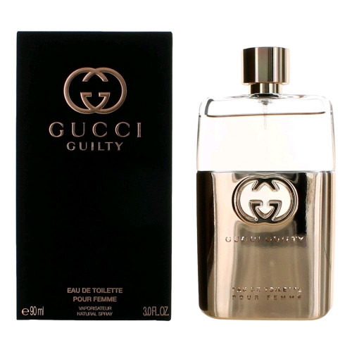 Gucci Guilty Pour Femme Eau de Toilette Spray 3 oz bottle placed on a white marble vanity with soft natural lighting, showing the gold-tone designer logo on the glass bottle and sealed retail packaging in the background