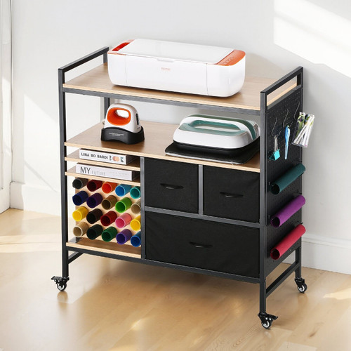 Rolling craft cart workstation in matte black, fully assembled with 20 colorful vinyl rolls stored vertically, a Cricut Maker machine on top, and crafting tools organized in drawers — ideal for home crafters and small business creators.