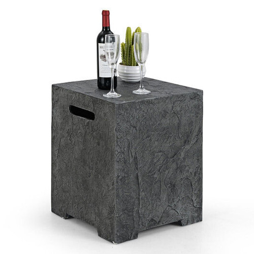 Gray stone-look propane tank hideaway table placed beside a fire pit, concealing a 20 lb propane tank while doubling as a stylish side table for drinks and decor in an outdoor patio setting.