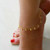 Leaflet Anklet for women featuring delicate gold leaf charms on an adjustable chain, worn on a bare ankle with soft natural sunlight highlighting its shine and lightweight design, perfect for summer, festivals, and layering with other jewelry.