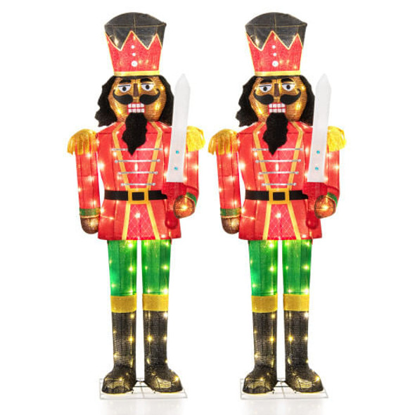 Pair of 5-foot tall lighted Christmas nutcrackers glowing on front porch with glitter swords and festive LED lights