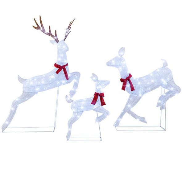 Three-piece white glitter reindeer family set glowing with cool white LED lights in a snowy front yard at night