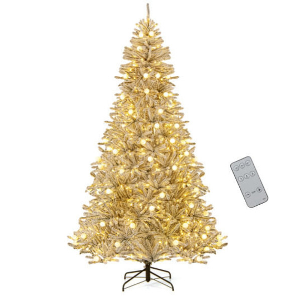 8-foot snow-flocked artificial Christmas tree fully assembled and lit with 81 warm-white sphere lights, standing in a cozy living room