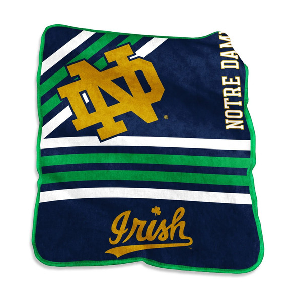 Official Notre Dame Fighting Irish Raschel Throw Blanket draped over a couch, featuring bold blue and gold school colors with the team logo centered, made of ultra-soft fleece fabric for premium comfort and fan pride. Official Notre Dame Fighting Irish Raschel Throw Blanket draped over a couch, featuring bold blue and gold school colors with the team logo centered, made of ultra-soft fleece fabric for premium comfort and fan pride.