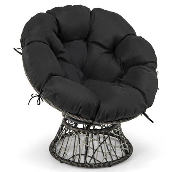 Black PE wicker papasan chair with thick removable cushion on a sunny balcony surrounded by potted plants, styled with a soft throw blanket and small side table for outdoor relaxation.