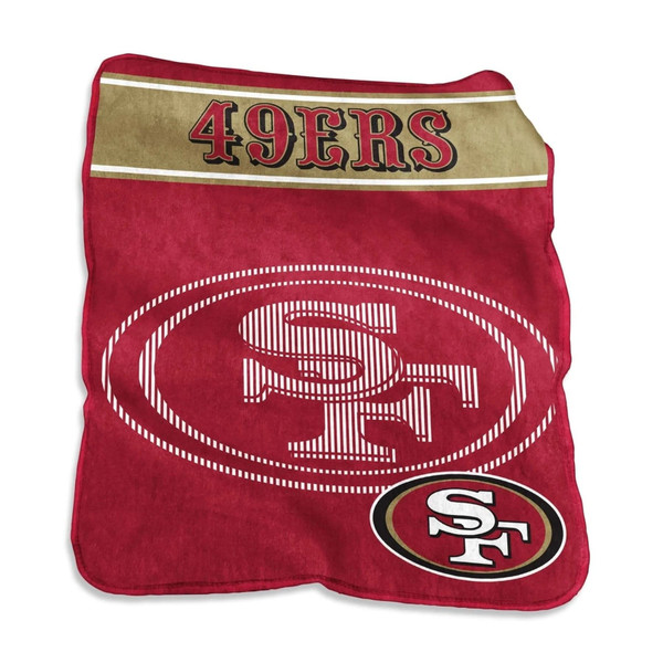 Official NFL San Francisco 49ers Raschel Throw Blanket draped over leather couch, showcasing bold red team logo and ultra-soft fleece texture in 60x80 oversized dimensions