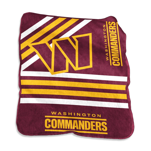 Official Washington Commanders Raschel throw blanket draped over a living room couch, showing bold team logo and vivid burgundy and gold colors on soft fleece fabric — perfect for NFL fans and game day comfort.
