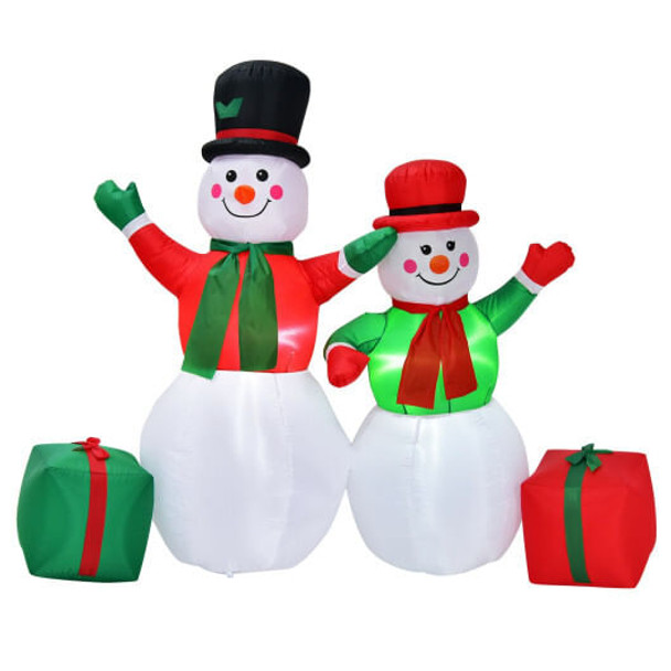 6-foot light-up inflatable snowman decoration glowing in a snowy front yard at night with bright white LED lights and a red scarf, creating a cheerful Christmas display.