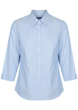 A light blue button-up shirt with long sleeves and a collar. Features a logo on the side.