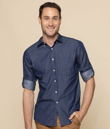 A button-up shirt in navy chambray fabric, featuring rolled-up sleeves and a fitted design. It has a logo on it.