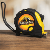 A tape measure in black and yellow, featuring a logo on its side, placed on a wooden surface.