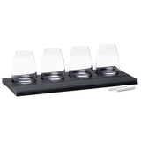 A wine tasting set featuring four clear glasses on a black wooden tray, accompanied by two white chalk sticks. A wine tasting set featuring four clear glasses on a black wooden tray, accompanied by two white chalk sticks.