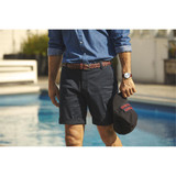Men's dress shorts in navy, featuring rolled hems and a patterned belt, paired with a casual shirt and cap.