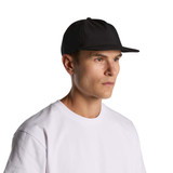 A black cap with a flat brim worn by a person in a white t-shirt. The cap features a logo. A black cap with a flat brim worn by a person in a white t-shirt. The cap features a logo.