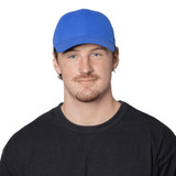 A blue organic cotton twill cap worn by a person, featuring a logo on the front. The individual is in a black shirt. A blue organic cotton twill cap worn by a person, featuring a logo on the front. The individual is in a black shirt.