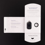A black Tile Pro tracker with a key ring, displayed in an open white packaging.