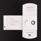 A white Tile Mate tracker packaged inside a recyclable box with a key ring. The box features a logo and instructions. A white Tile Mate tracker packaged inside a recyclable box with a key ring. The box features a logo and instructions.