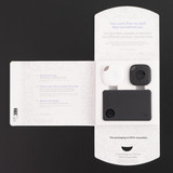 A Tile Combo Pack featuring a black and white tracking device, presented in a cardboard package with a design.