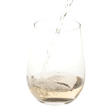 A clear stemless wine glass with a pour of liquid creating bubbles inside. A clear stemless wine glass with a pour of liquid creating bubbles inside.