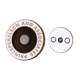 A soft enamel magnetic ball marker in brown and white with a logo, featuring a circular design and a smaller circular piece.