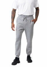 A person wearing grey men's three-layer cotton sandwich pants, featuring an elastic waistband and side pockets.