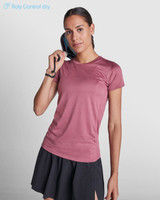 A pink women's T-shirt made from moisture-wicking fabric, paired with a black skirt, featuring a logo.