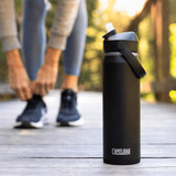 A drink bottle in matte black with a flip straw, featuring a handle and branding.