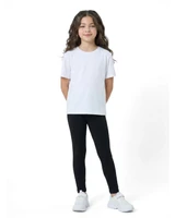 A child wearing black leggings paired with a plain white T-shirt and white sneakers, smiling confidently.