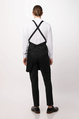 A black Largo Bib Apron with cross-back straps, worn over a white shirt and black pants.