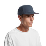 A navy blue cap with a structured front, featuring a logo, worn by a person in a white shirt.