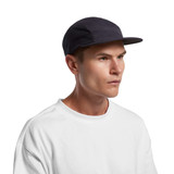 A cap in navy blue with a mesh design, featuring a branded logo, worn by a model with a neutral expression.
