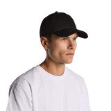 A black cap worn by a model, featuring a curved brim and a fitted design. The model is in a casual white T-shirt.