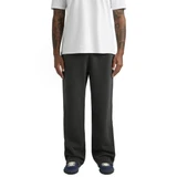 A pair of relaxed, cuffless track pants in black, worn with a white shirt and athletic shoes.