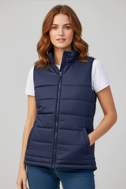 A navy women's alpine vest featuring a zip front, padded design, and side pockets. The model is wearing a white T-shirt underneath.