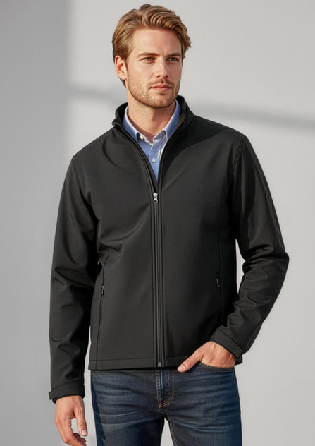 A man wearing a black soft shell jacket, standing against a neutral background, featuring a logo on the jacket.