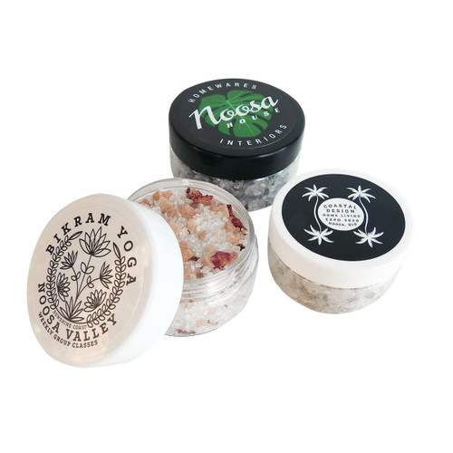 Three jars of bath salts in various designs, featuring pink and white salts with floral decorations. Each jar has a distinct lid design. Three jars of bath salts in various designs, featuring pink and white salts with floral decorations. Each jar has a distinct lid design.