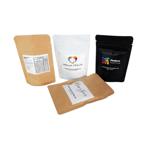 A set of four pouches containing Organic Matcha Green Tea, featuring brown and black packaging with varied labels. A set of four pouches containing Organic Matcha Green Tea, featuring brown and black packaging with varied labels.