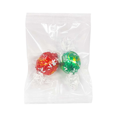 A clear plastic wrapper containing two chocolate balls, one red and one green, individually wrapped. A clear plastic wrapper containing two chocolate balls, one red and one green, individually wrapped.