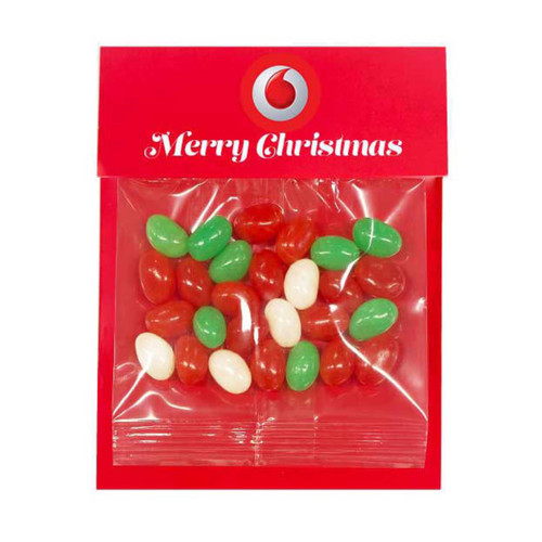 A festive red packaging containing assorted jelly beans in red, green, and white colours, featuring a logo. A festive red packaging containing assorted jelly beans in red, green, and white colours, featuring a logo.