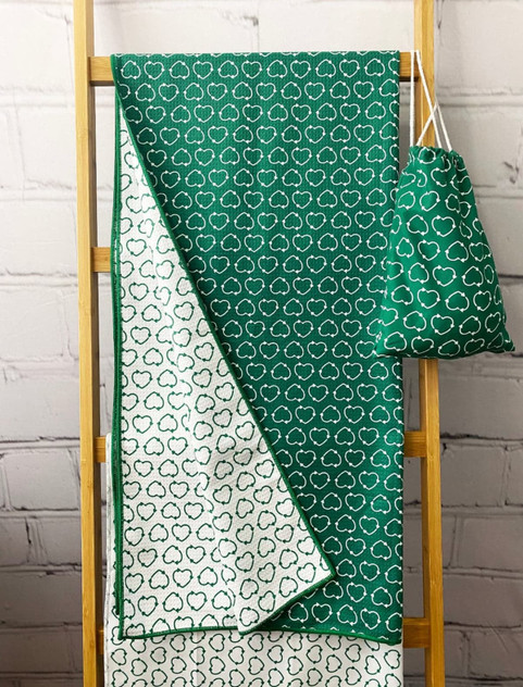 A green rPET beach towel with a cloud pattern, hanging next to a matching drawstring pouch. A green rPET beach towel with a cloud pattern, hanging next to a matching drawstring pouch.