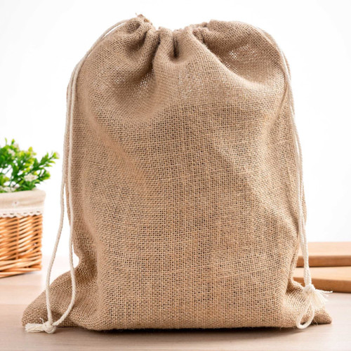 A natural jute bag with a drawstring closure, featuring a textured surface and cream-coloured cords.