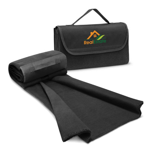 A black fleece blanket with a carry handle and a logo on the front, partially unfolded. A black fleece blanket with a carry handle and a logo on the front, partially unfolded.