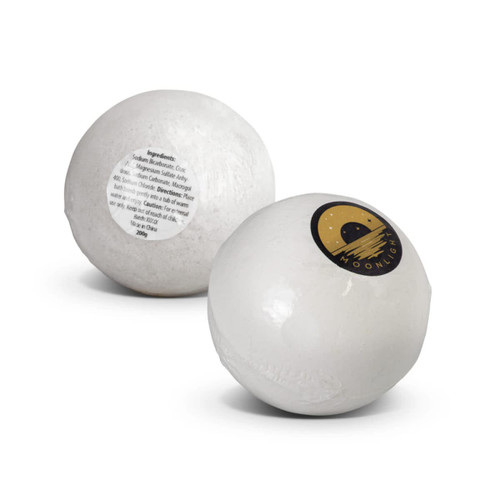 A white bath bomb with a logo featuring a crescent moon, displaying a label with ingredients.