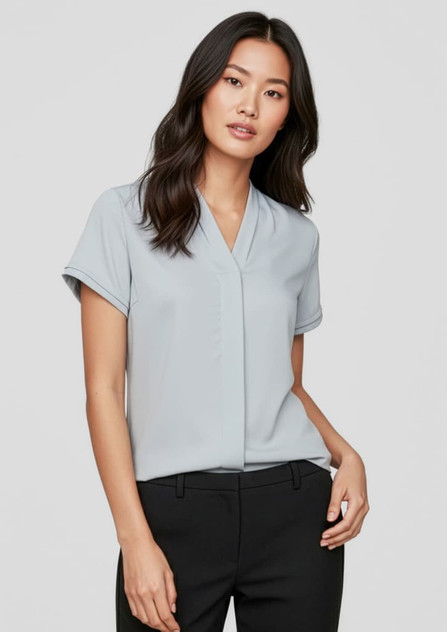 A light blue women's short sleeve button-up shirt displayed on a model, featuring a v-neckline and rolled sleeves.