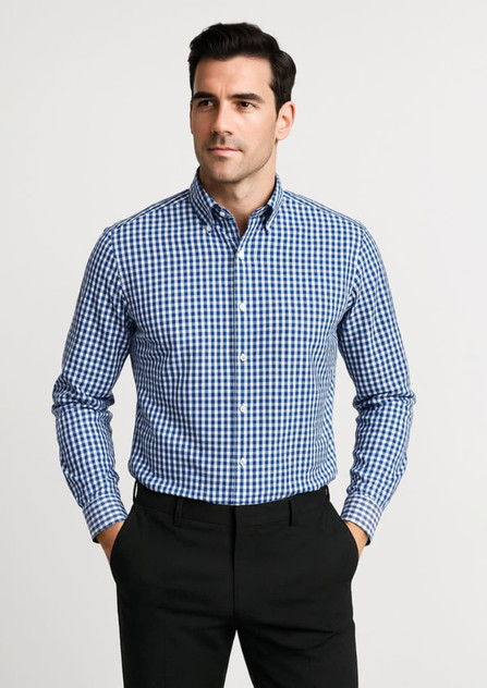 A blue and white checked long sleeve button-up shirt featuring a collar and a logo. The model stands with hands in pockets.