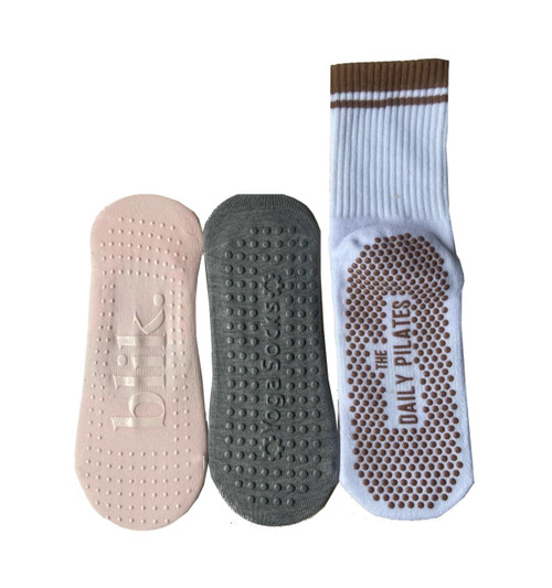 Custom grip socks in pink, grey, and white with textured bottoms for added traction. Each sock features a logo.