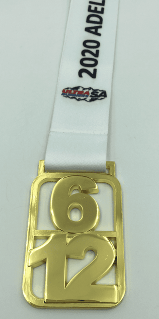 A gold medal with a white ribbon, featuring the numbers 6 and 12, and a logo.