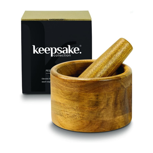 A wooden mortar and pestle set in a round bowl, displayed with a black box featuring a logo.